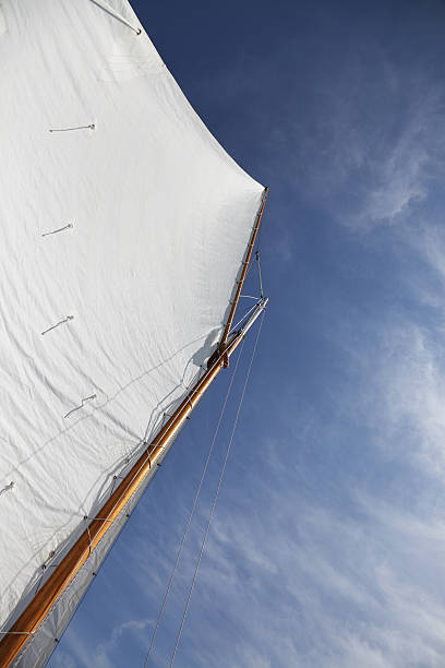 Gaff Rigged Sail on a Yawl A yawl main mast with a gaff rigged main sail and a jib. This sailboat is underway under a blue, high wispy cloud summer sky. This image also works quite well as a horizontal - flipped 90 degrees to the left. :) gaff sails stock pictures, royalty-free photos & images