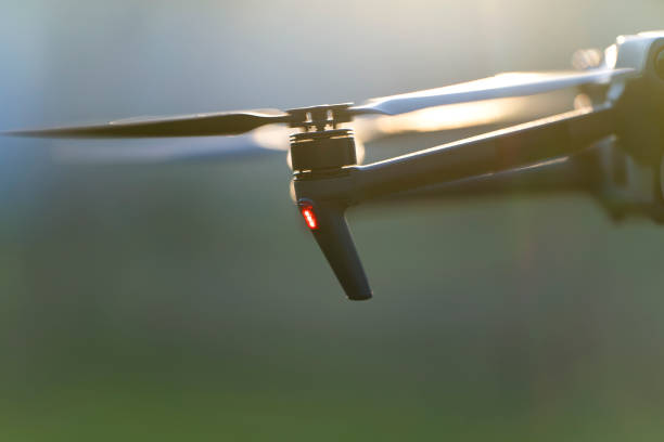 istock Drone aircraft with blurred fast rotating propellers and video camera flying in air 1755315387