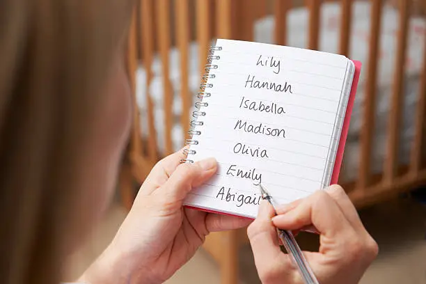 Photo of Woman Writing Possible Names For Baby Girl In Nursery