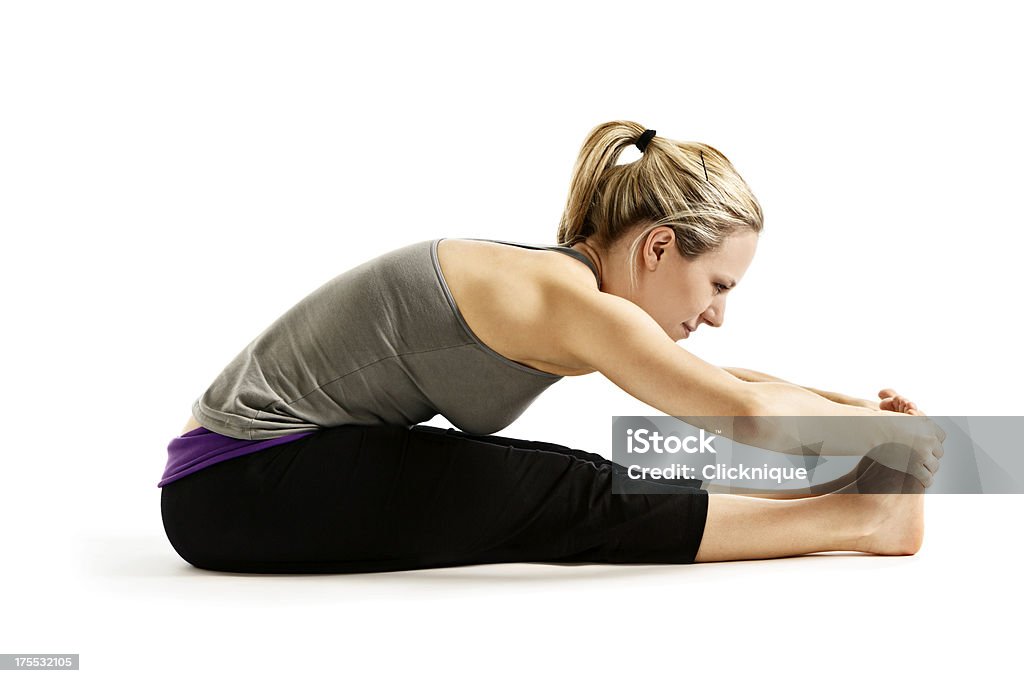 Giovane donna dimostrando Paschimottanasana o postura yoga seduti piegare in avanti - Foto stock royalty-free di Abbigliamento sportivo
