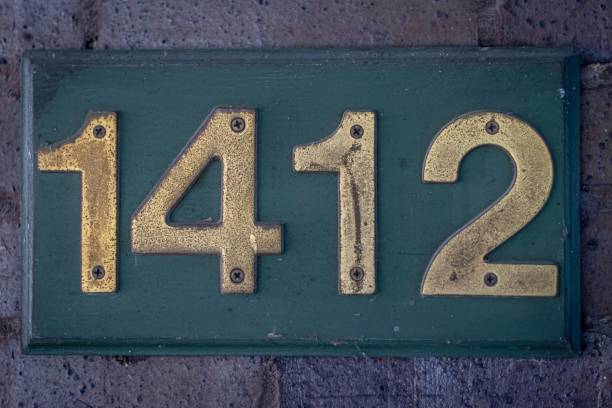 Isolated close up high resolution image of a rustic hose number with red bricks in the background