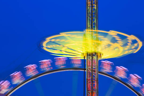 spinning de loisirs - blurred motion amusement park spinning lighting equipment photos et images de collection