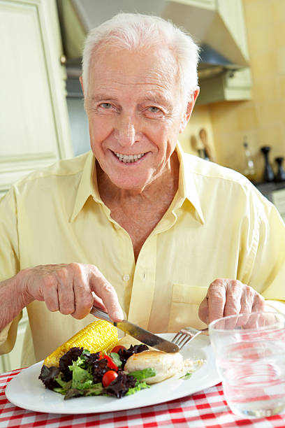 istock Senior Man Eating Meal In Kitchen 175532302