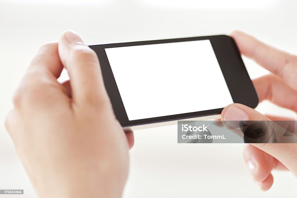 Mãos segurando um telefone inteligente com tela em branco, branco. - Foto de stock de Horizontal royalty-free