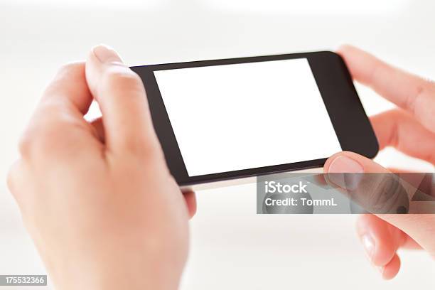 Foto de Mãos Segurando Um Telefone Inteligente Com Tela Em Branco Branco e mais fotos de stock de Horizontal