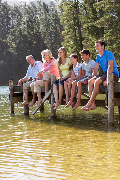 istock Three Generation Family Sitting On Wooden Jetty Looking Out Over 175533731