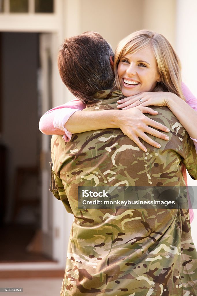 Soldier Returning Home And Greeted By Wife Soldier Returning Home And Greeted By Wife Smiling While Hugging Husband Stock Photo