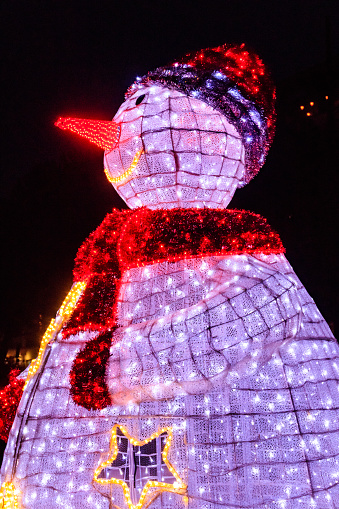 Illuminated snowman at night. Decoration for Christmas and New Years holidays in a city park