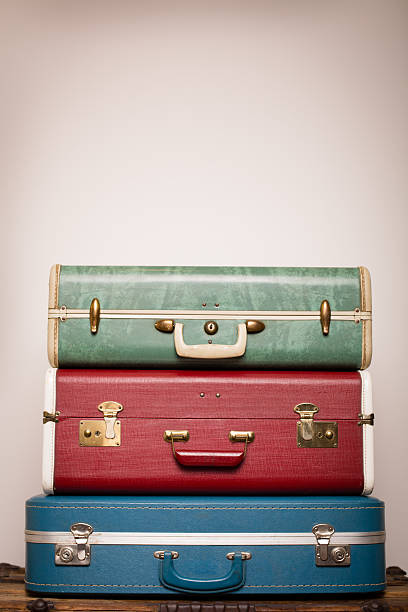 Three Retro Suitcases Stacked on Wood Trunk, With Copy Space stock photo