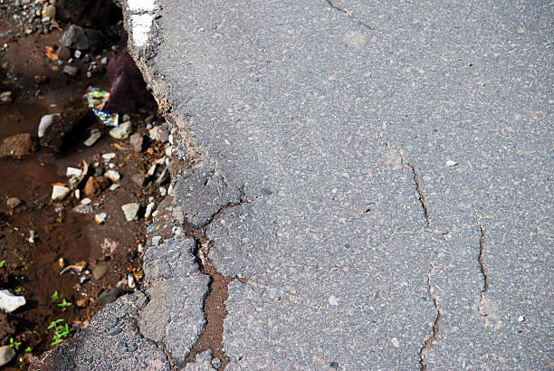 beschädigte verwaschenes highway - asphalt damaged riverbed construction stock-fotos und bilder