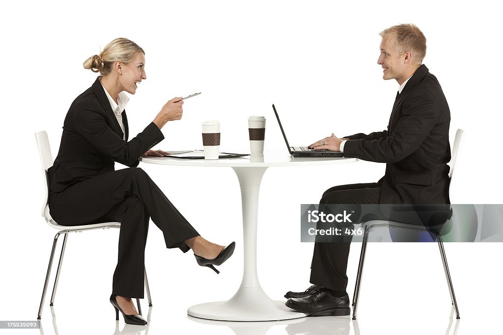 Pareja de negocios sonriendo a otro en un restaurante. - Foto de stock de Fondo blanco libre de derechos