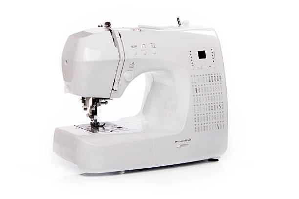 A sewing machine, different types of cloth and sewing accessories arranged on a table