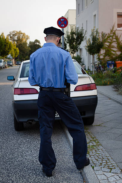 istock police officer in blue uniform writes a parking ticket 175537475