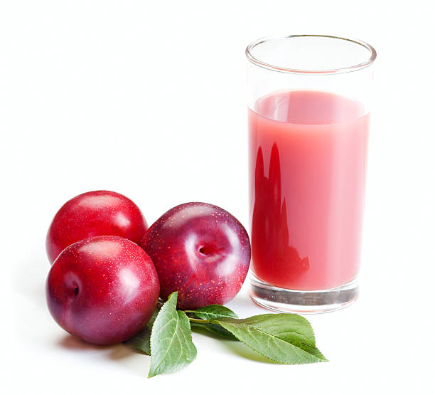 Fresh plums and prune juice isolated on white Fresh plums and a glass of prune juice isolated on white plum red white purple stock pictures, royalty-free photos & images