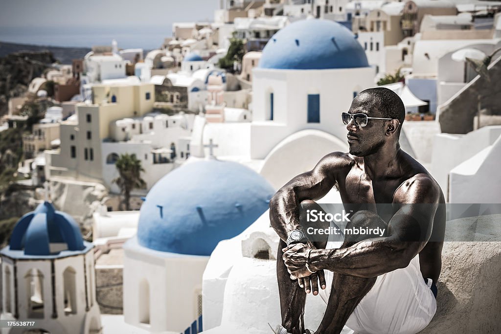 Uomo godendo le vacanze nel villaggio di Oia, Santorini island - Foto stock royalty-free di 45-49 anni