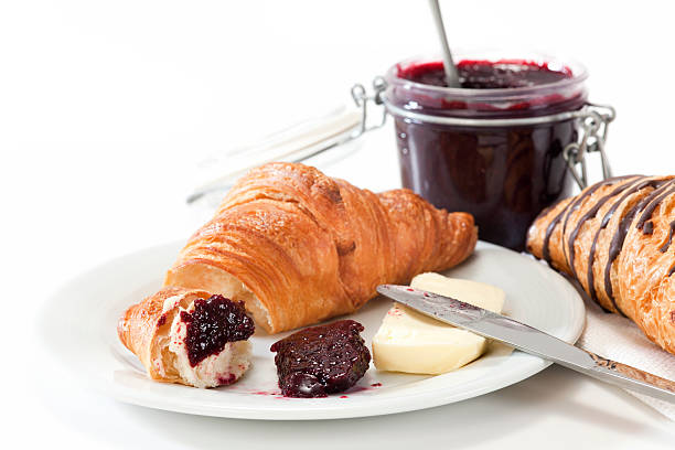 Breakfast with croissant, butter and marmalade. Selective focus, shallow DOF.