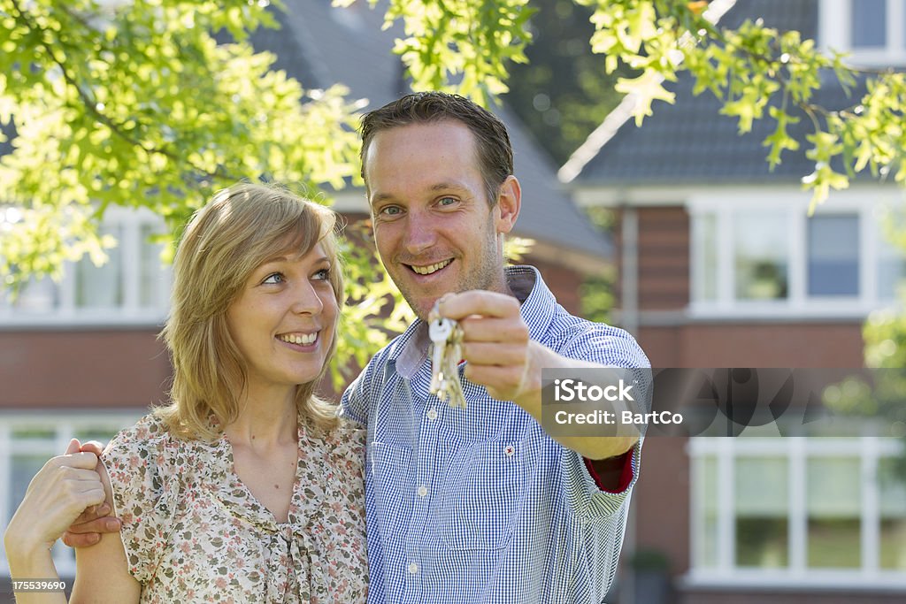 Joven pareja en frente de casa. - Foto de stock de Casa libre de derechos