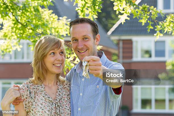 Joven Pareja En Frente De Casa Foto de stock y más banco de imágenes de Casa - Casa, Delante de, Edificio residencial