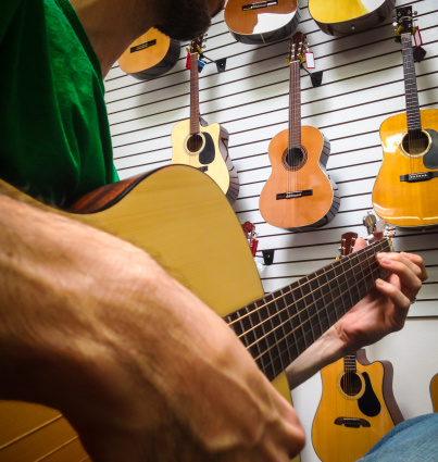 Man playing guitar in store.