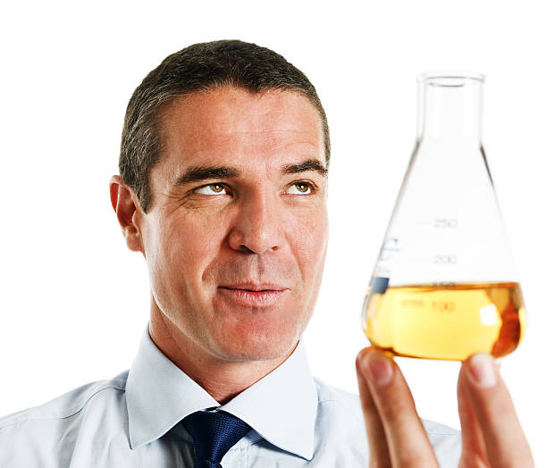 istock Handsome mature man smiles at yellow liquid in lab flask 175540433