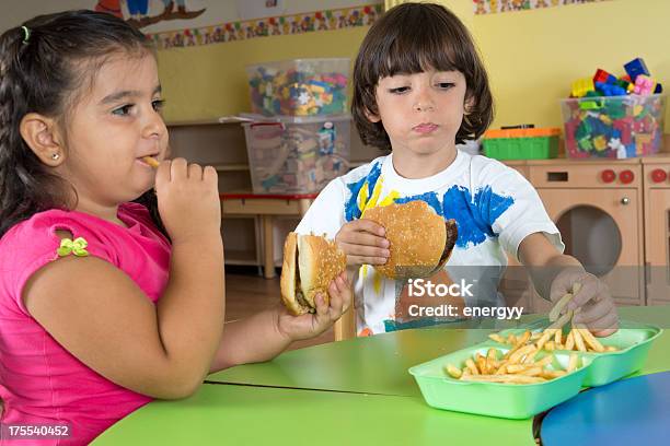 Bambini Con Hamburger E Patatine Fritte - Fotografie stock e altre immagini di 4-5 anni - 4-5 anni, Affamato, Alimentazione non salutare