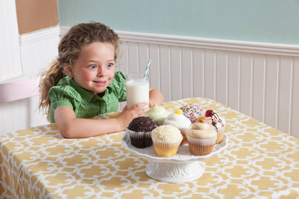 menina com um copo de leite e cupcakes - sc0563 - fotografias e filmes do acervo