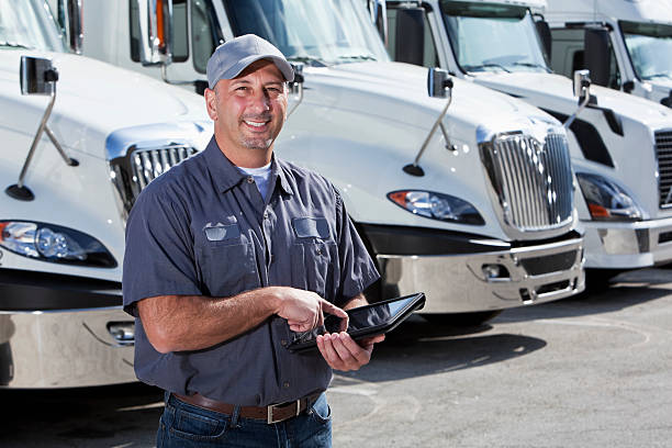 istock Truck driver in front of big rigs with digital tablet 175540732