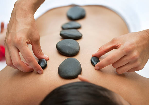 Warm stone massage at spa Hands massaging upper back with warm stones. You may also like: hot stone massage stock pictures, royalty-free photos & images