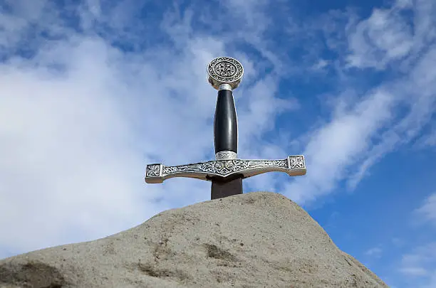 Arthur's sword is thrust into the rock. It is photographed from bottom against the sky.