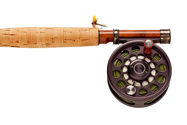 Close up of the handle of a fly-fishing rod & reel with a yellow fly. Works as a Horizontal OR Vertical shot.