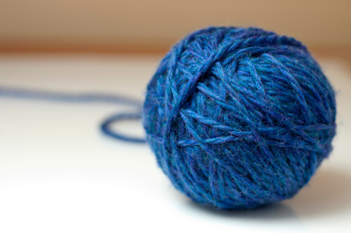 Ball of blue wool or yarn on a white background