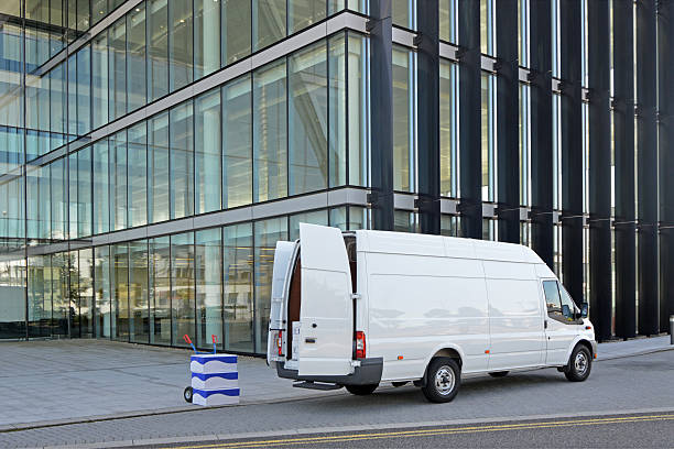 Van Delivery A white van delivering boxes to a modern office block. unloading photos stock pictures, royalty-free photos & images