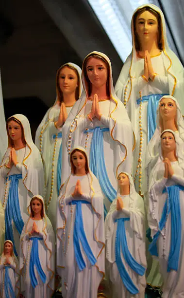 Statues of Virgin Maria in a religious shop in the street to Lourdes