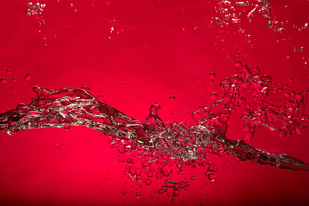 rosso spruzzi d'acqua - moisten foto e immagini stock