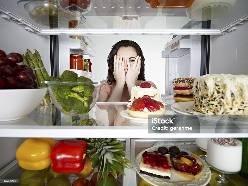 Donna guardando a una torta - Foto stock royalty-free di Frigorifero