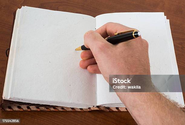 Writing In Empty Leatherbook Diary Or Guestbook With Ballpoint Pen Stock Photo - Download Image Now