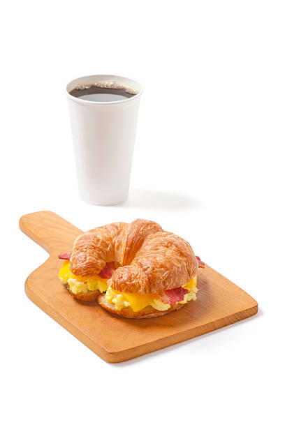 Croissant Breakfast Sandwich with Egg, Cheese, Bacon and Coffee "Croissant breakfast sandwich with egg, cheese, bacon, and a blank cup of coffee you can easily remove or add your own logo to." breakfast sandwhich stock pictures, royalty-free photos & images