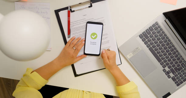 istock Young woman working from home paying online from phone. 1755437478