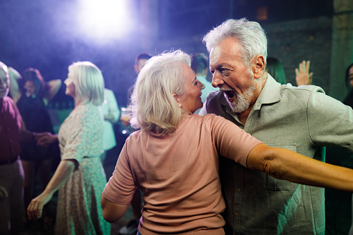 Happy senior couple having fun while dancing during nightlife in a club.