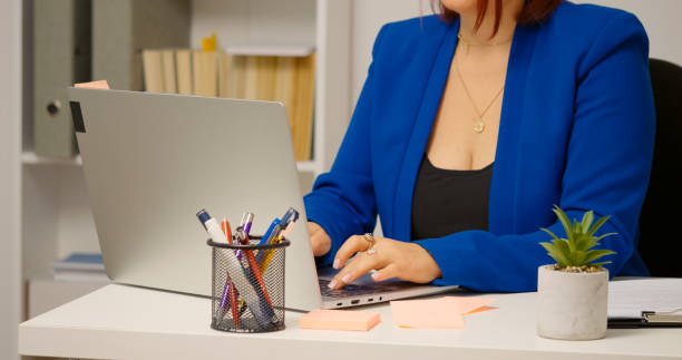istock Office worker typing term report on laptop at desk in workplace. 1755439671