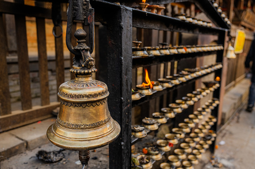 Close up of bell and lit candles in Buddhist temple in Kathmandu, Nepal