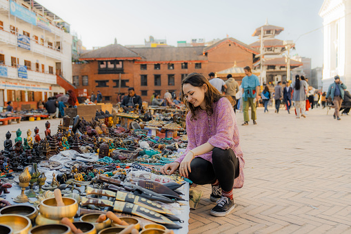 Female tourist buying souvenirs on Durbar square in Kathmandu, Nepal