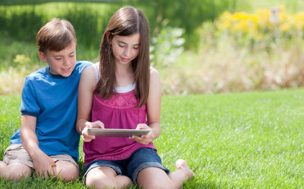 istock Boy and Girl Playing with a Computer Tablet 175544378