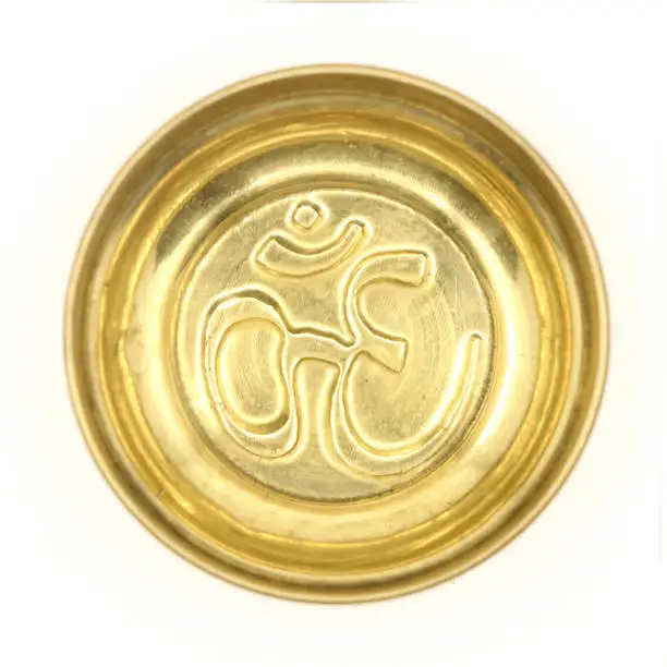 Photo of a golden prayer bowl with an antique hindu om symbol