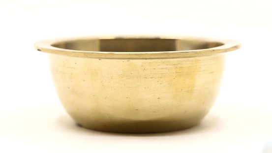 closeup of empty gold bowl plate used in the kitchen as a symbol of classic luxury isolated in a white background