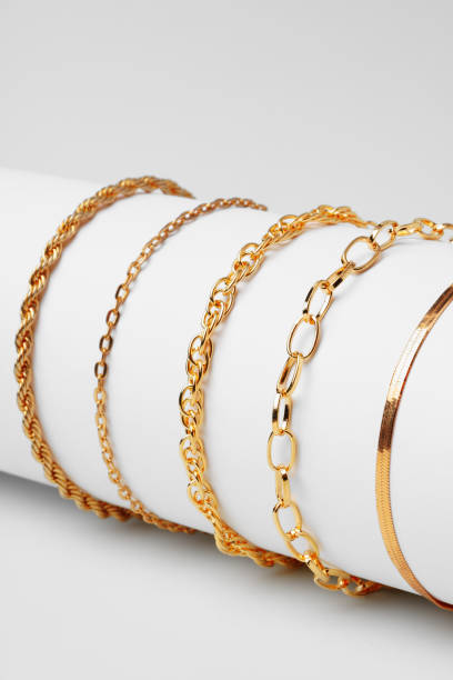 istock Set of golden bracelets on display on white background 1755446149
