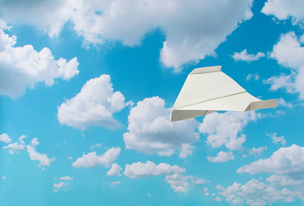 istock Flying white paper airplane against blue sky with copy space 175544792