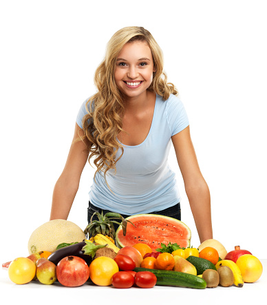 A pretty young woman standing with delicious fresh produce while isolated on a white background