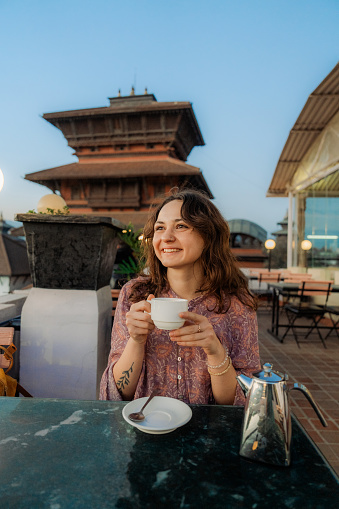 Woman drinking tea with view of ancient town in Kathmandu, Nepal