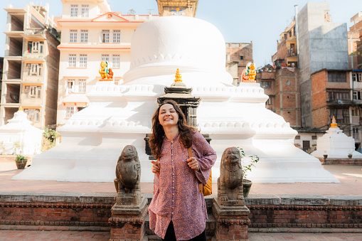 Cheerful woman on the background of white stupa in Kathmandu, Nepal